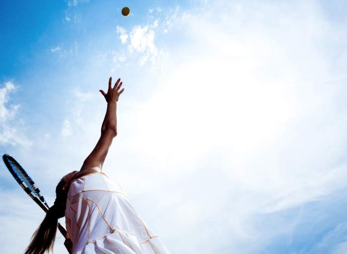 Woman serving a Tennis Ball